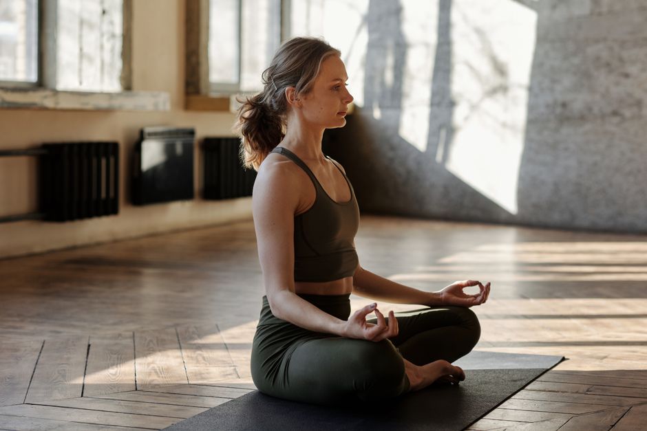 Mulher meditando em posição confortável focando no presente para controlar a ansiedade